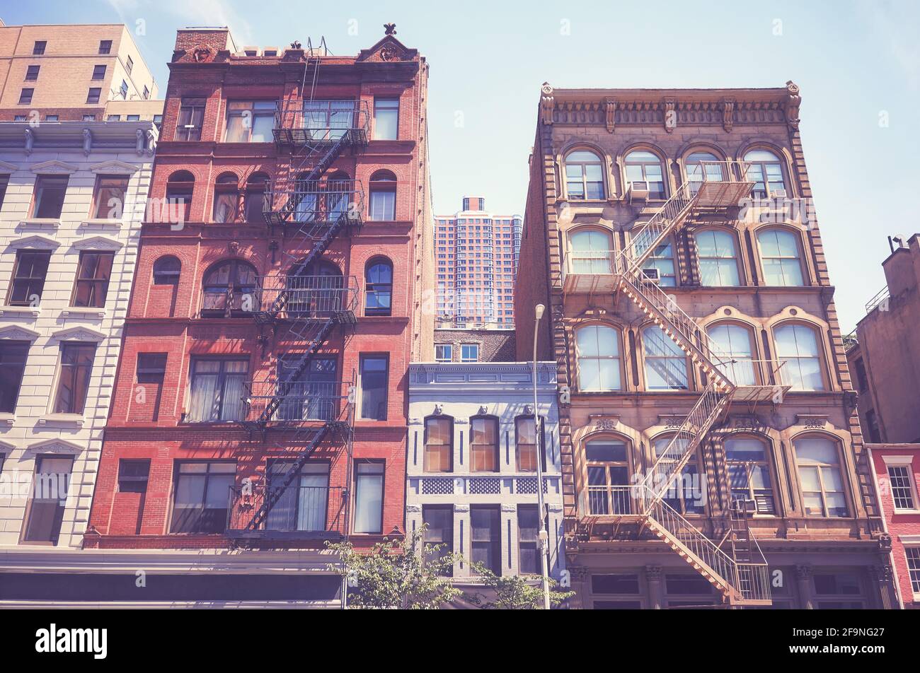 Old buildings with fire escapes in New York City, color toning applied, USA. Stock Photo