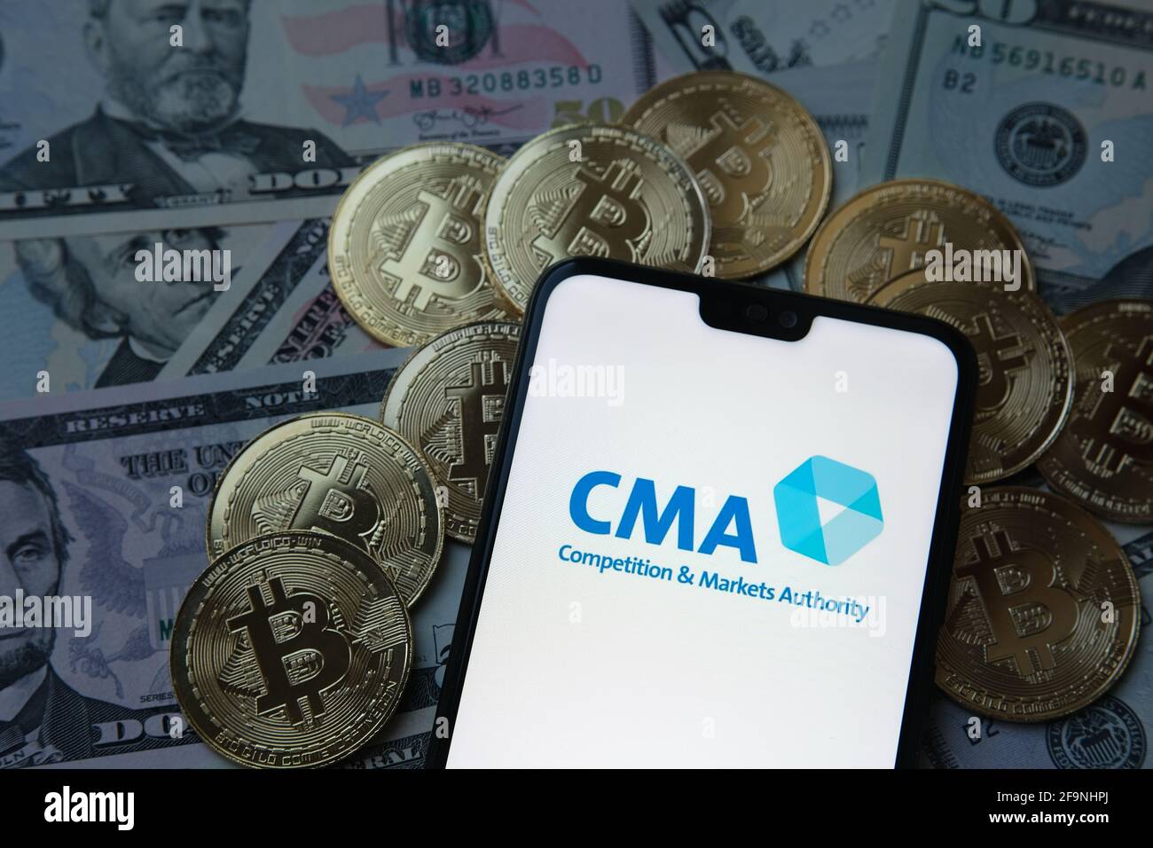 CMA competition and markets authority logo, bitcoins, dollars. Stock Photo