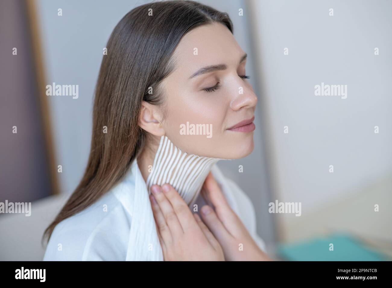 Young woman with hands on neck hi-res stock photography and images - Alamy