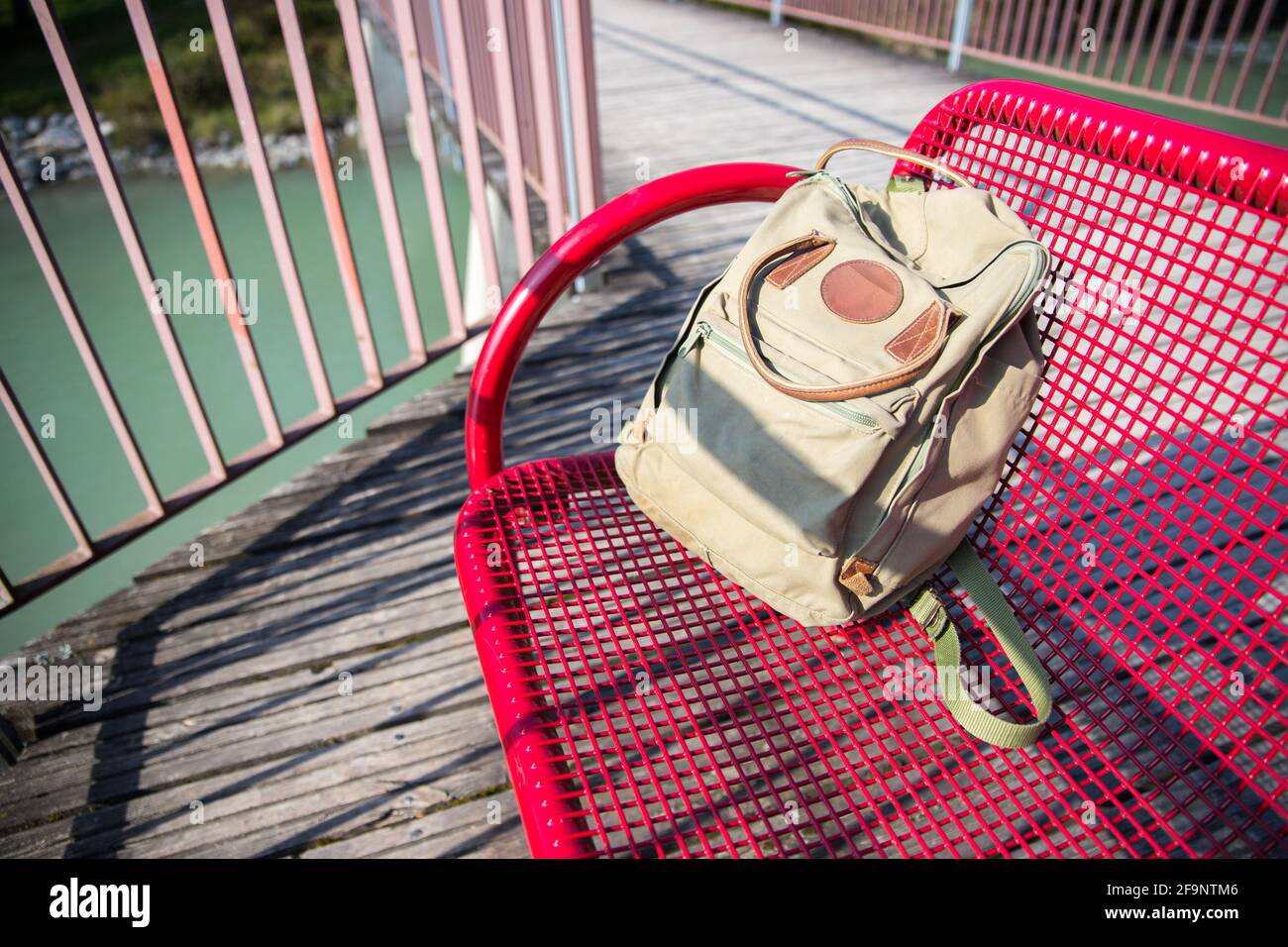 Vintage backpack is lying on red bench Stock Photo