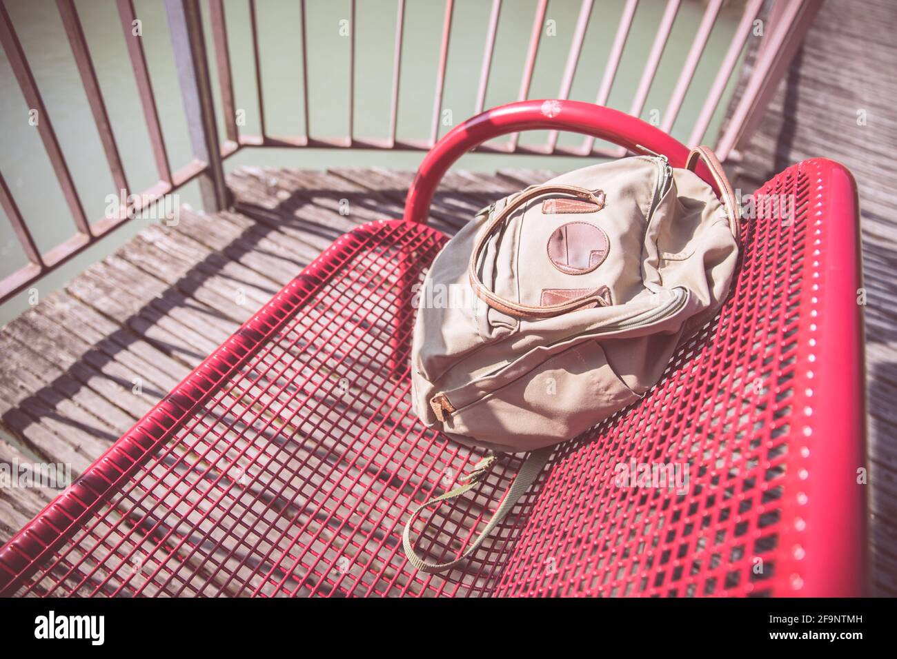 Vintage backpack is lying on red bench Stock Photo