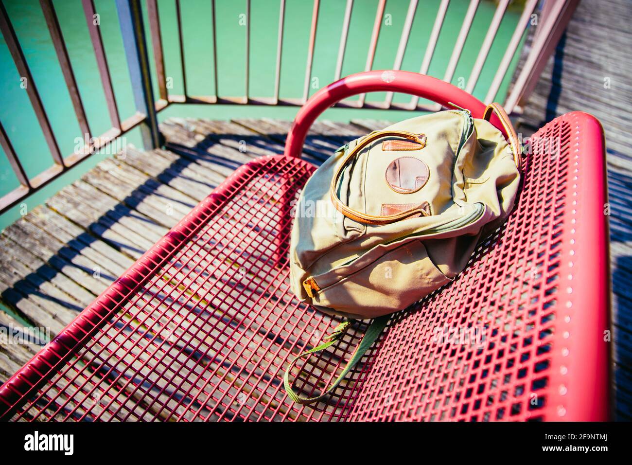 Vintage backpack is lying on red bench Stock Photo