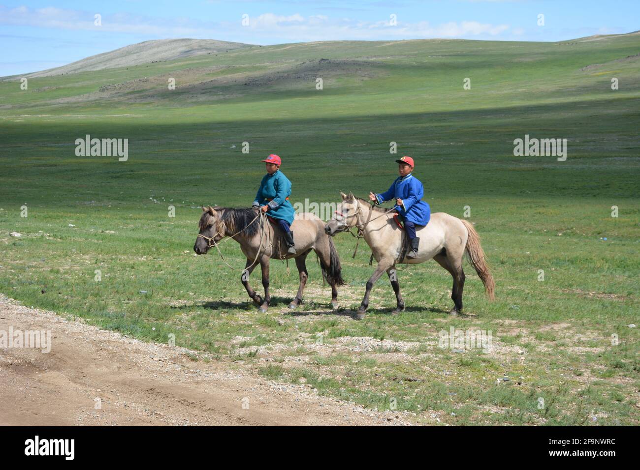 Child nomadic herders in traditional dress on horseback on the steppes of the Orkhon Valley area of Mongolia, Central Asia. Stock Photo