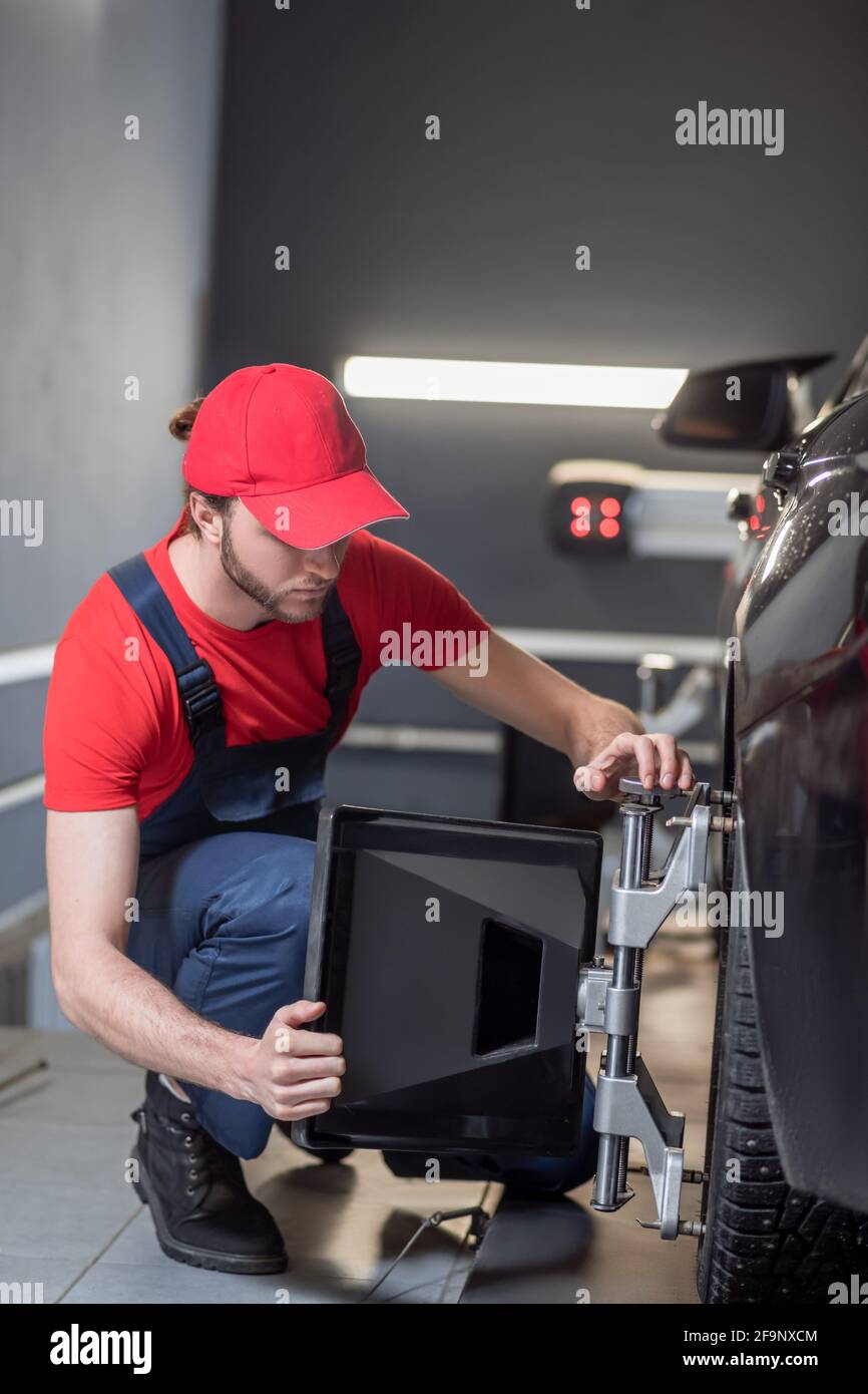 Auto mechanic installing wheel alignment stand Stock Photo Alamy