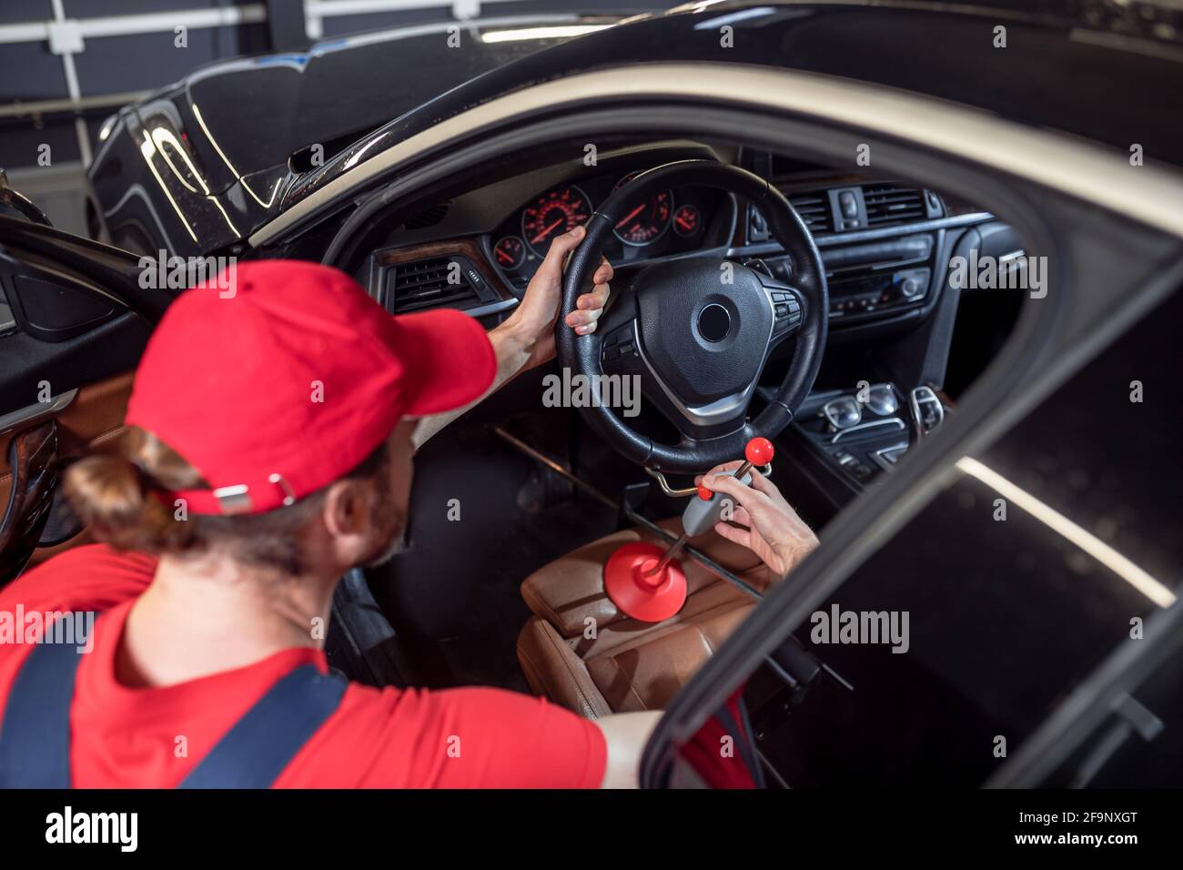 Car service worker adjusting steering wheel in car Stock Photo
