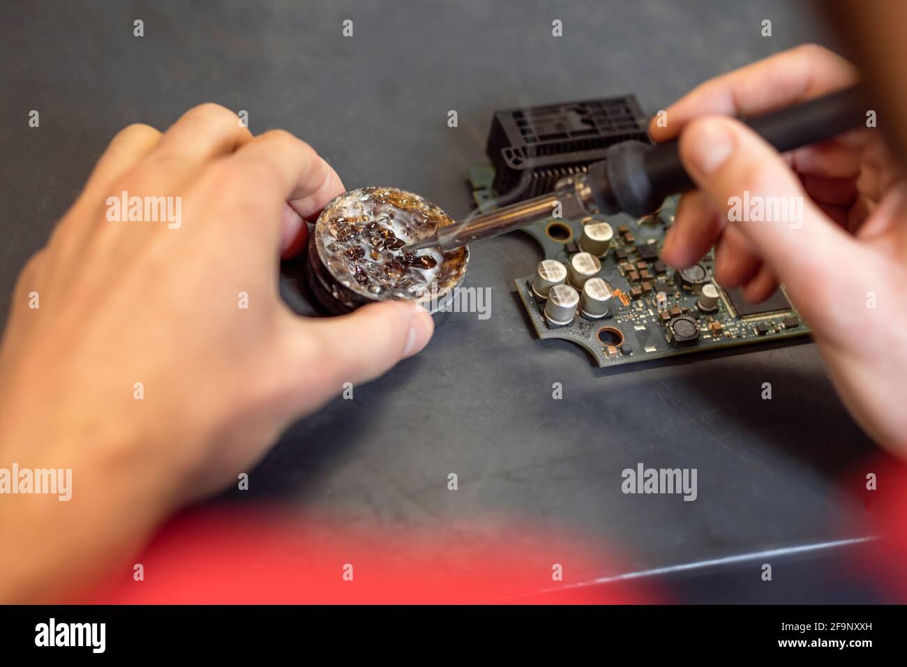 Male hands holding soldering iron near solder Stock Photo Alamy