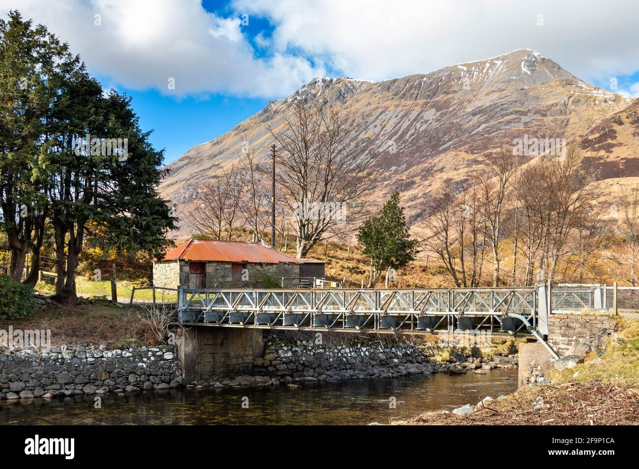 GLENELG HIGHLANDS SCOTLAND THE METAL BRIDGE OVER RIVER ARNISDALE AT CORRAN AND SNOW CAPPED BEINN SGRITHEALL Stock Photo