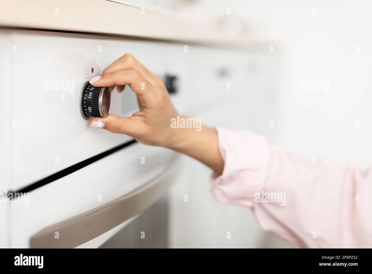 Woman using stove cooking food in kitchen Stock Photo