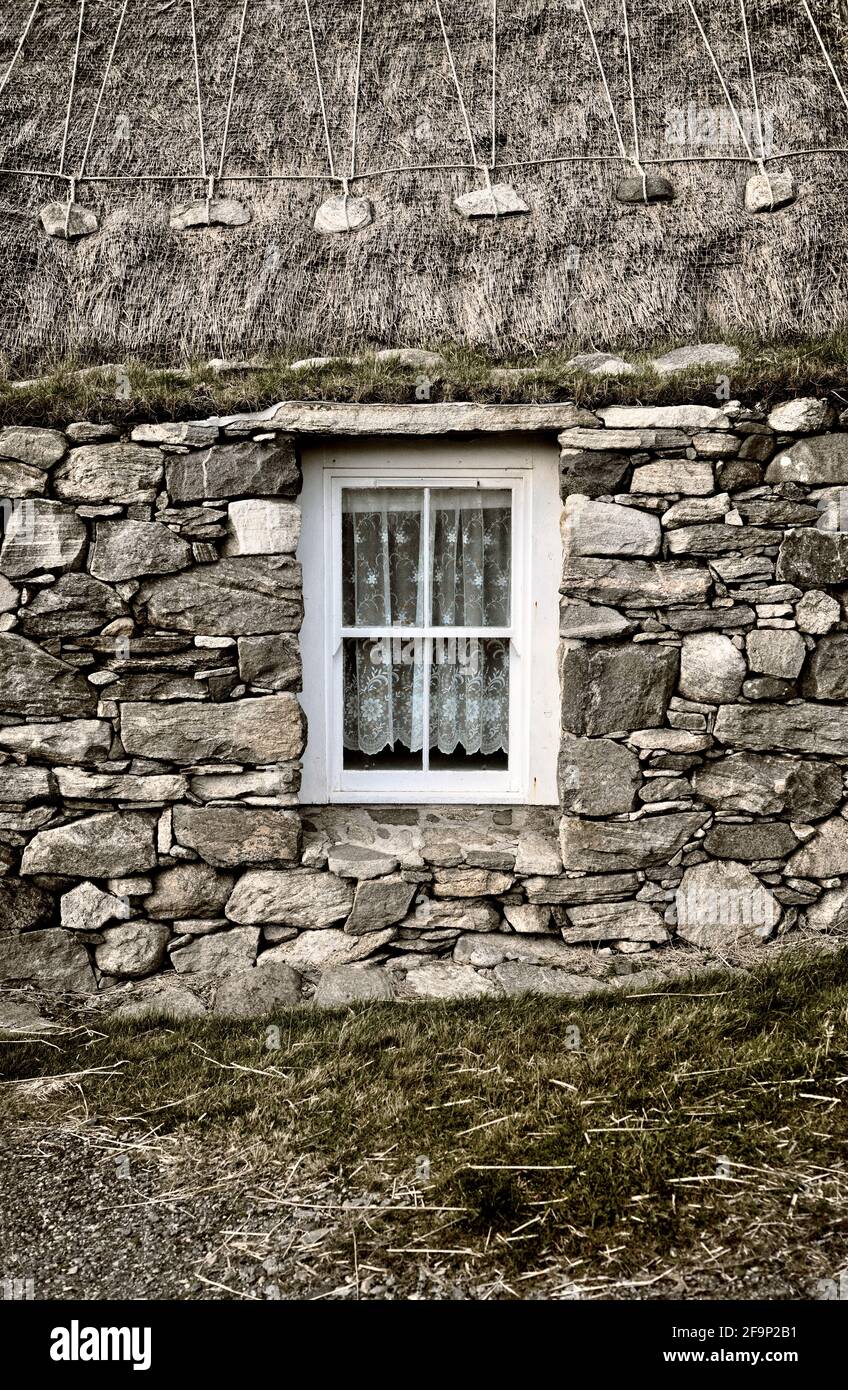 Blackhouse Village. Restored crofting fishing township of Garenin, Na Gearrannan. Lewis, Outer Hebrides.  Lived in until 1974. Thatch and croft window Stock Photo