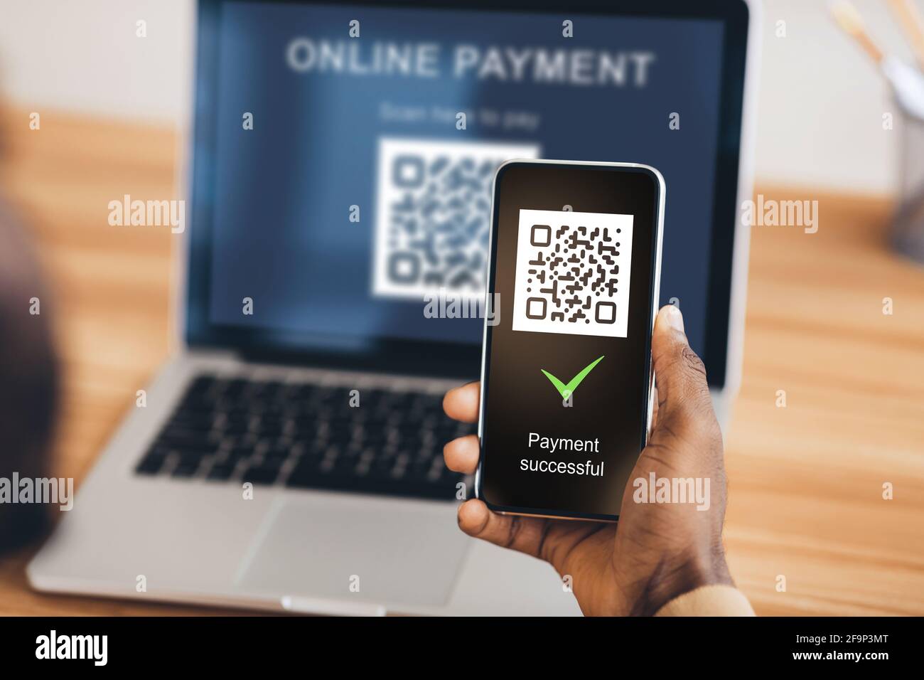 Black man scanning qr code from laptop with smartphone Stock Photo - Alamy