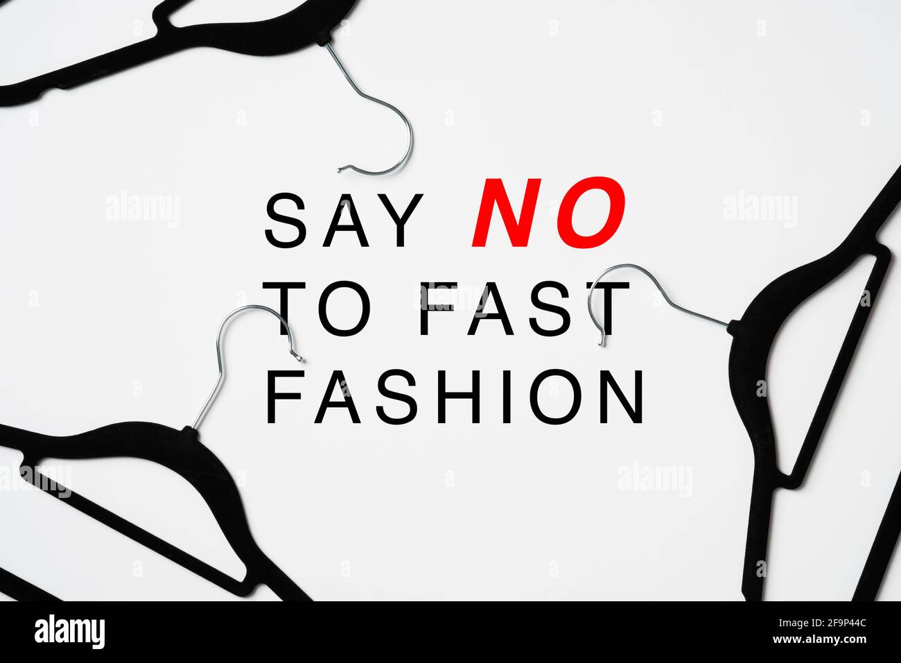 Say No To Fast Fashion sign over heap of hangers on white background.. Fast Fashion is bad for the environment Stock Photo
