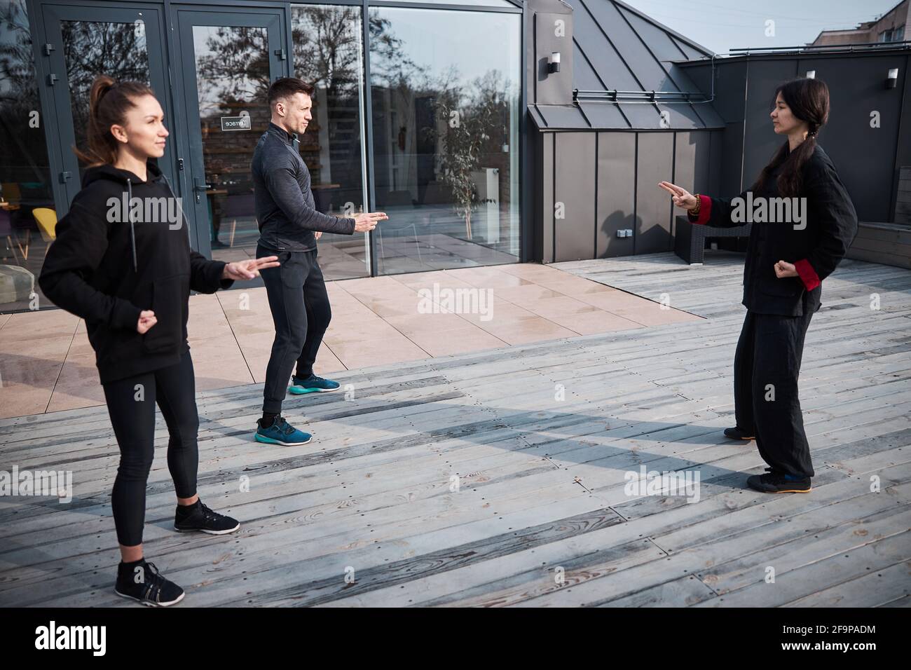 Master teaching two-finger tai chi gesture to class Stock Photo