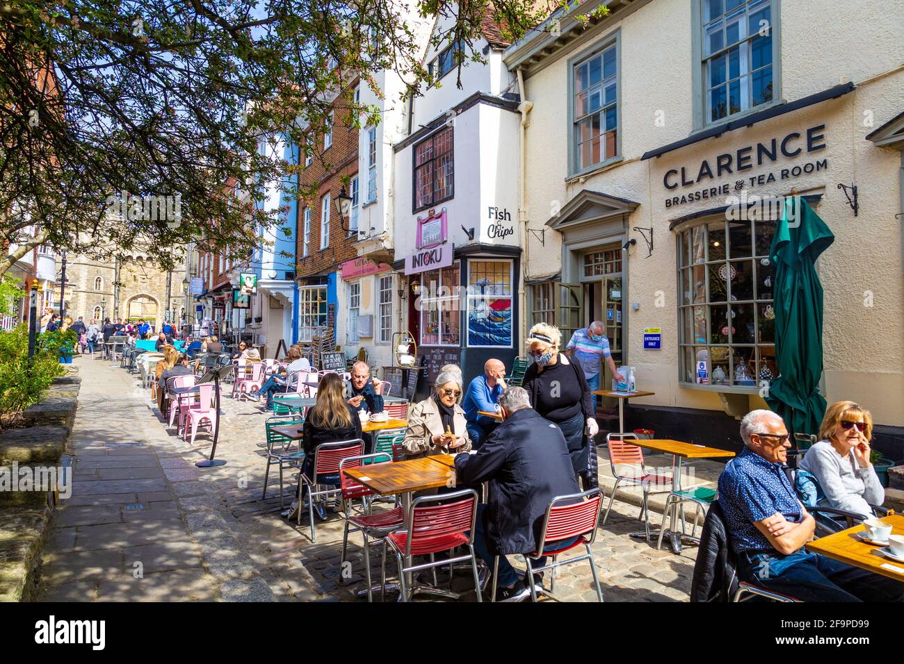 People dining al fresco on charming Church Street with restaurants and Windsor Castle in background, Windsor, Berkshire, UK Stock Photo