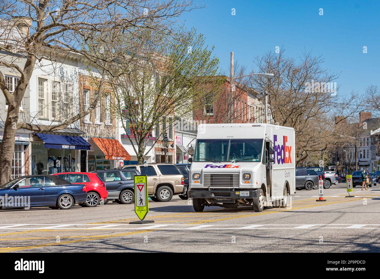 A Fedex Box truck parked in the middle of a main street making deliveries Stock Photo