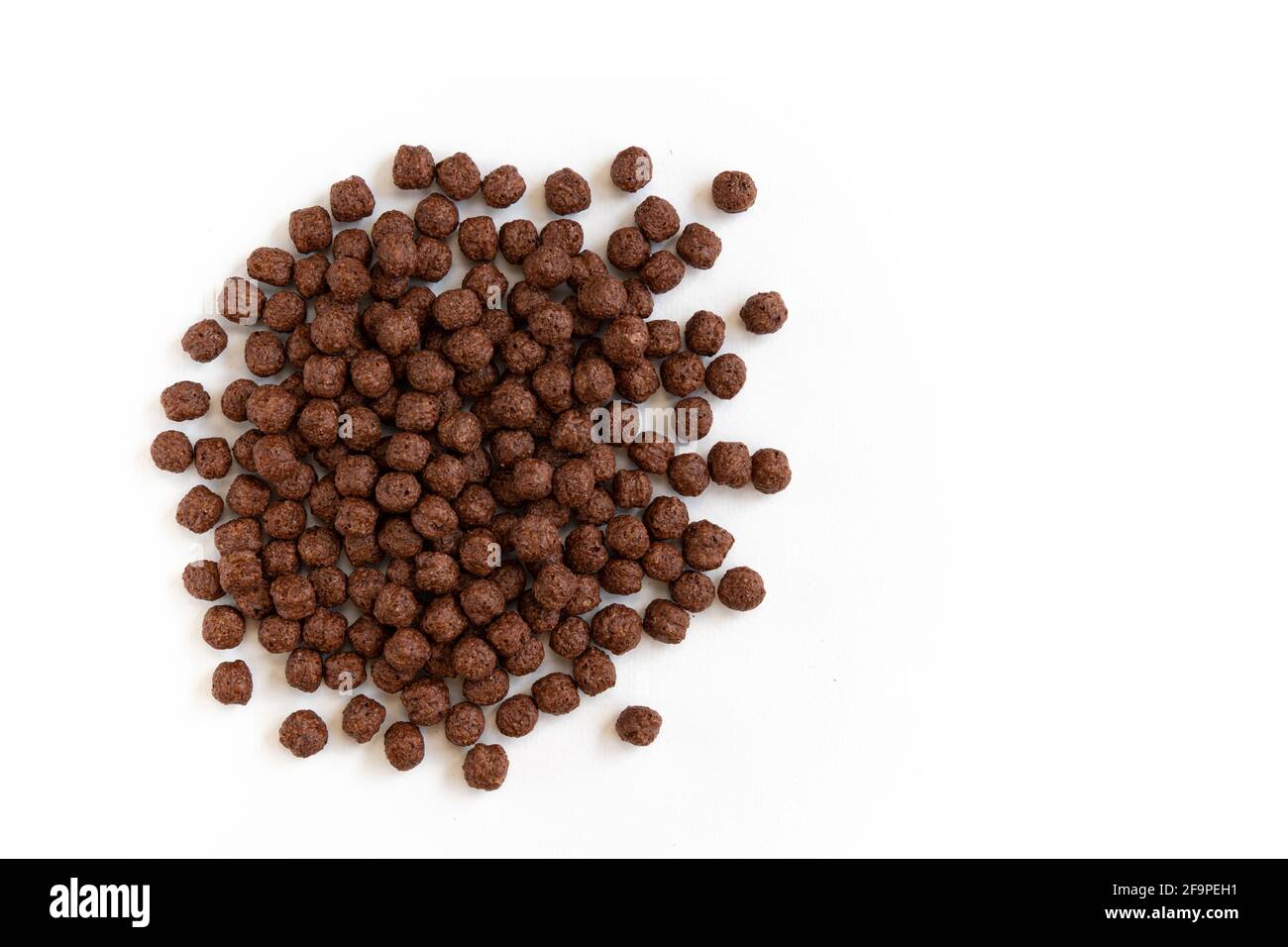 crunchy chocolate cereal balls isolated on white background, dry breakfast chocolate flavored balls, top view Stock Photo