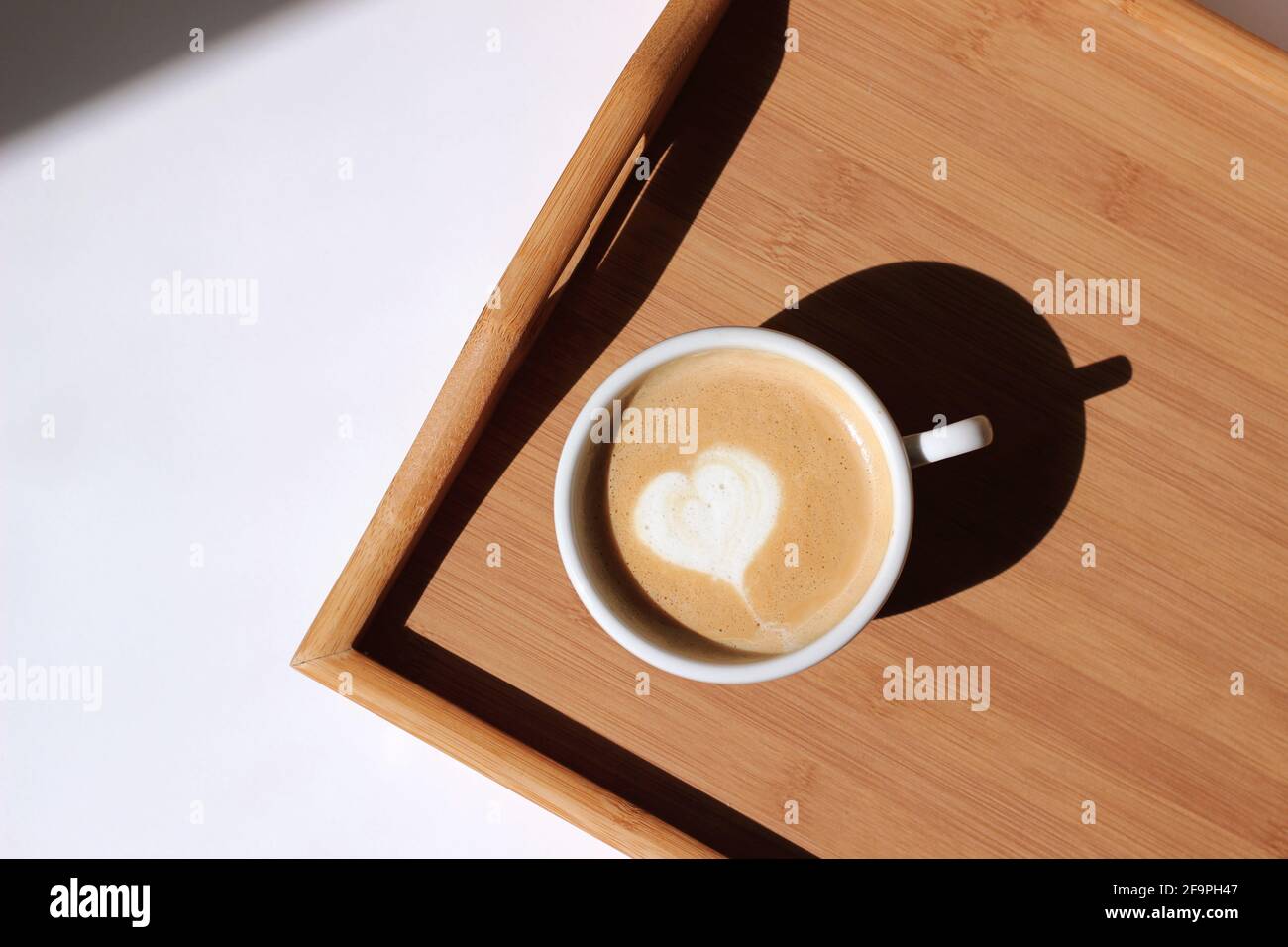 Cappuccino with Latte Art Served on Wooden Tray. Drinking Morning Coffee at Home. Stock Photo