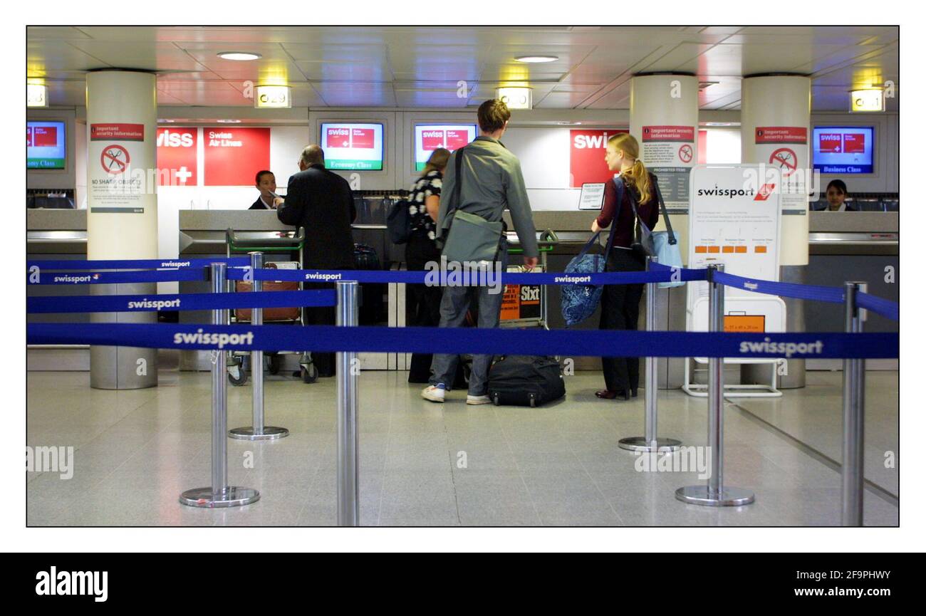 Travelers queue at Heathrow airport....for poss use with 25% decrease of air traffic in Swiss airspace.pic David Sandison 7/7/2002   travel tourist tourism Stock Photo