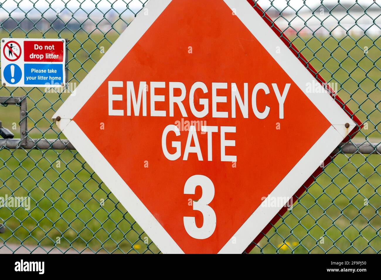 Emergency crash gate at airport runway red diamond warning sign. Gates
