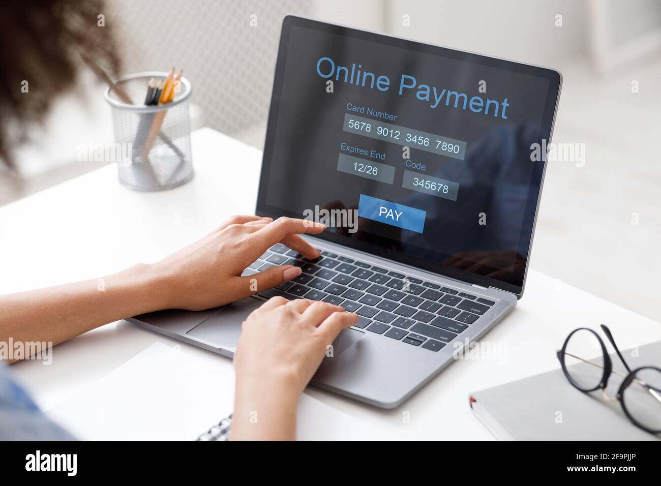 Black lady filling payment form, using laptop at office Stock Photo
