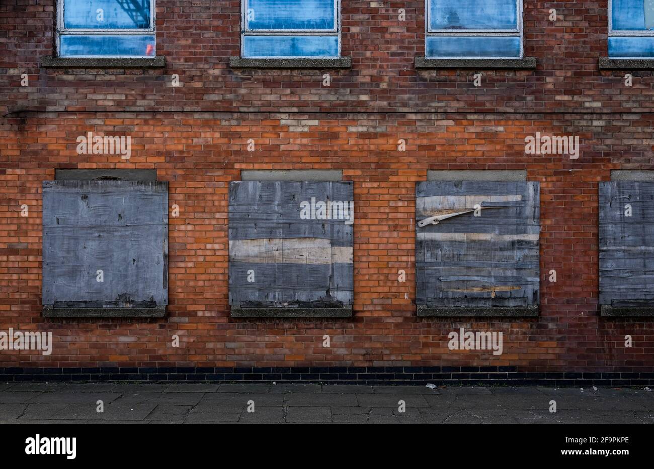 The boarded up windows of a derelict fish merchants warehouse in the port of Grimsby emphasises the decline in the fishing industry worsened by Brexit Stock Photo