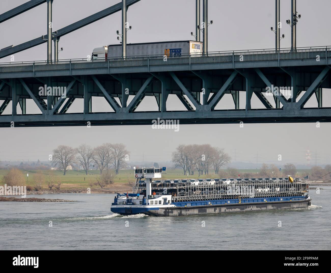 03.03.2021, Krefeld, North Rhine-Westphalia, Germany - Cargo ship with new car, in front on the Krefeld-Uerdingen bridge at the Rhine port Krefeld dri Stock Photo