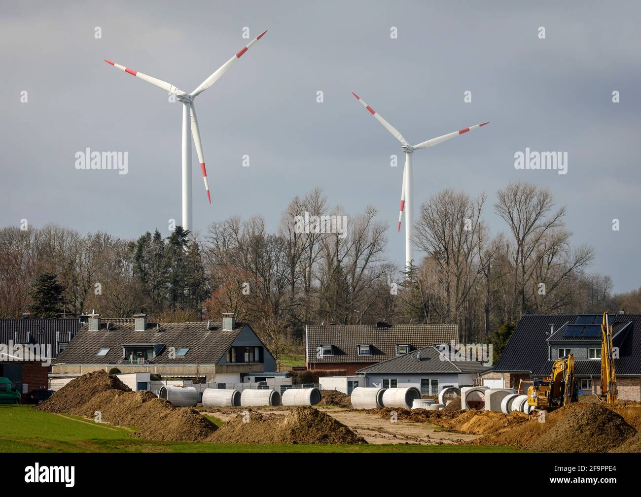 16.03.2021, Juechen, North Rhine-Westphalia, Germany - Canal construction in new housing estate in front of wind farm at RWE opencast lignite mine Gar Stock Photo