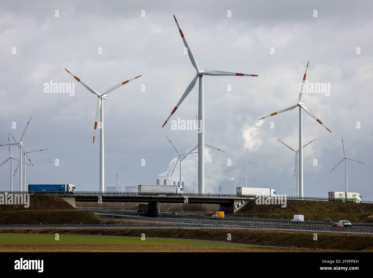 16.03.2021, Grevenbroich, North Rhine-Westphalia, Germany - Truck on freeway and wind farm in front of RWE power plant Neurath, lignite-fired power pl Stock Photo