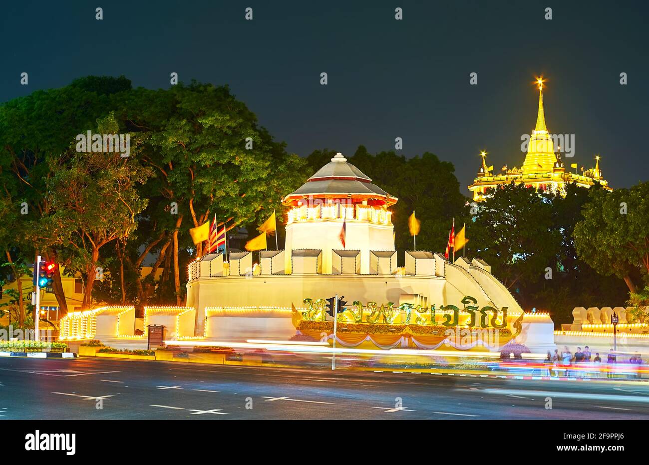 The medieval Phra Sumet Fort and the picturesque stupa of the Golden Mount Temple, seen behind the greenery of Santichaiprakarn Park, Bangkok, Thailan Stock Photo