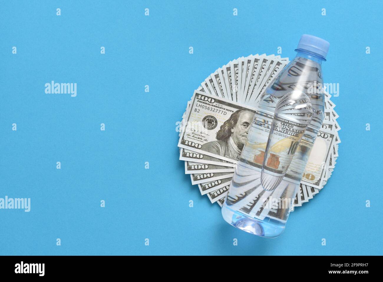Plastic bottle lies on dollars Stock Photo
