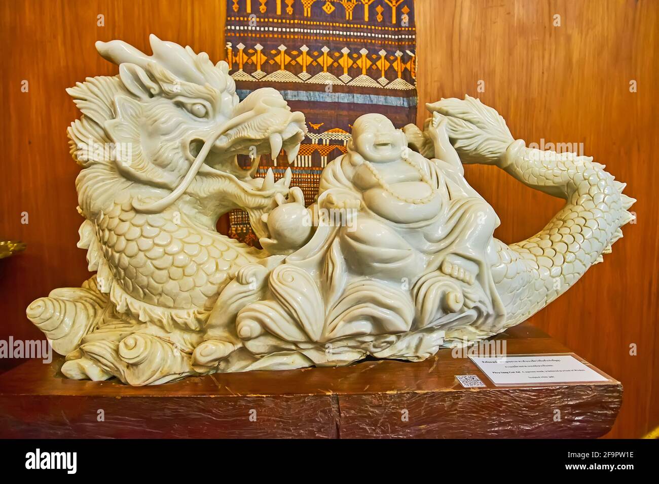 CHIANG RAI, THAILAND - MAY 11, 2019: The white jade sculpture of the God of Wisdom (Phra Sang Gut Jai), sitting on the dragon, Museum of Wat Phra Kaew Stock Photo