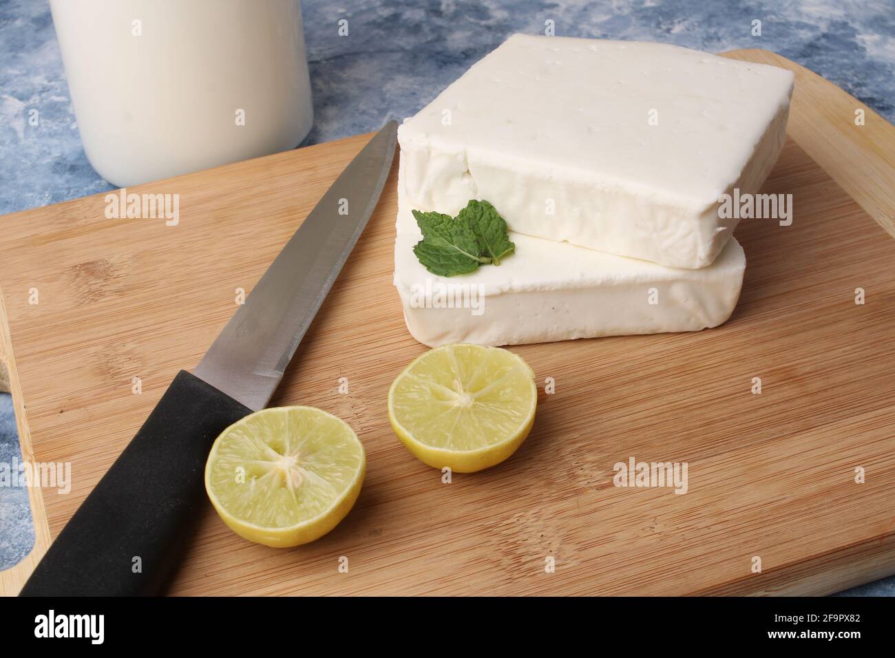 paneer making recipe ingredients, milk and lemon with fresh cottage cheese. Stock Photo