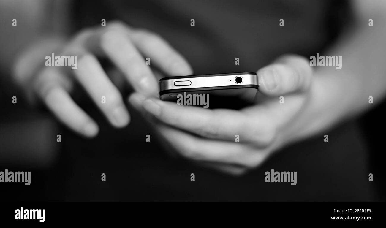 Person holding smart phone in hands to communicate and text Stock Photo