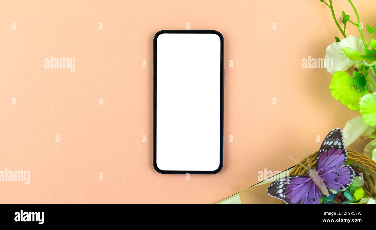 Spring workspace mockup with blank white screen of mobile phone, beige  background with flowers and butterfly, flat lay mother's day concept photo  Stock Photo - Alamy
