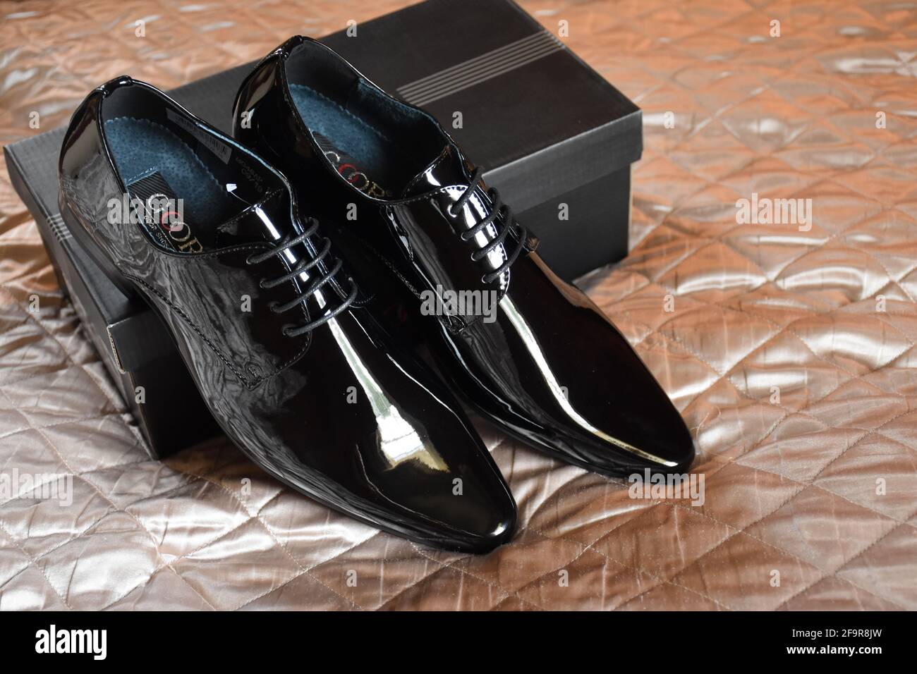 New black mens shoes on the bed Stock Photo