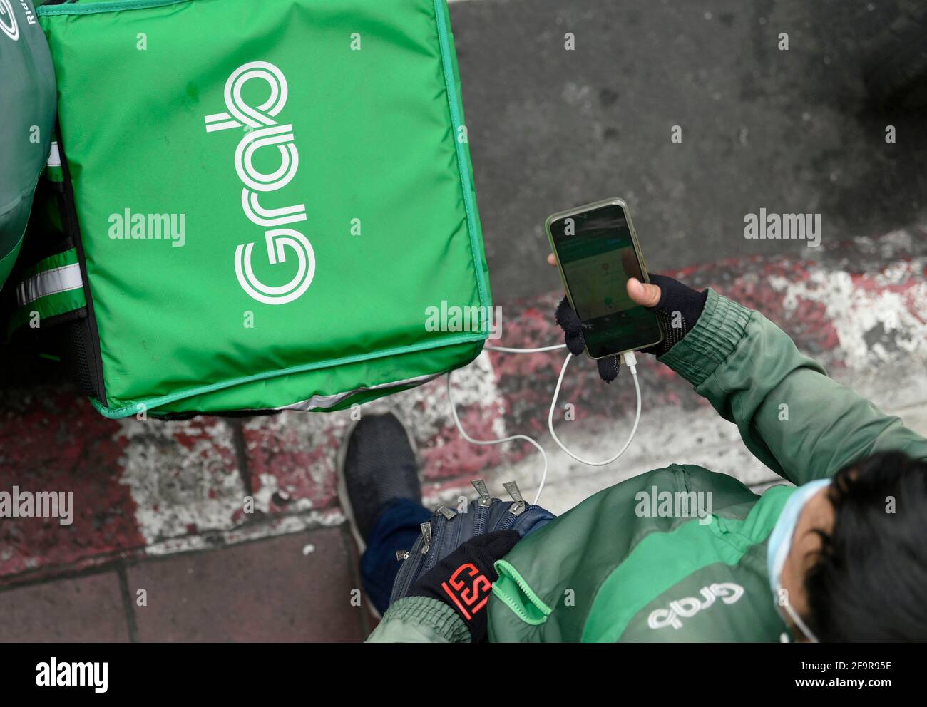 Bangkok Thailand 20th Apr 2021 A Grab Motorcycle Rider Checks His Mobile Phone During The Covid 19 Pandemic The Grab Home Food Delivery Service Network Has Expanded With Thousands Of Former Motorcycle Taxi Riders