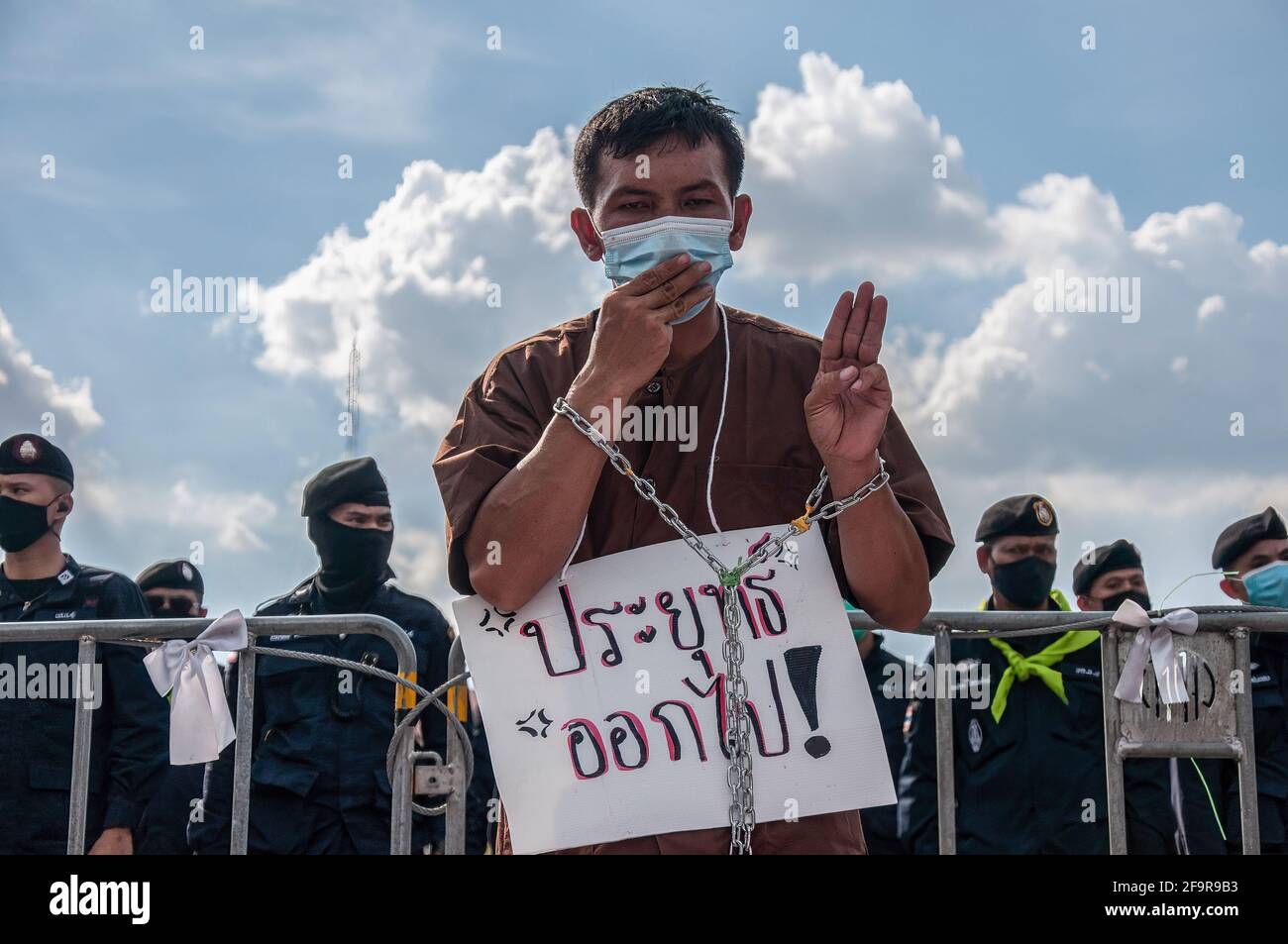 Bangkok, Thailand. 20th Apr, 2021. A protester makes a three-finger salute with chains wrapped around his hands during the demonstration. Protesters dress as prisoners during a demonstration outside the Government House in Bangkok to demand the release of detained pro-democracy activists who were charged by lese majeste law (Article 112 of the Thai criminal code). Pro-democracy protesters will stand silently for 112 minutes, a reference to the lese majeste law that is being actively used against the activists. Credit: SOPA Images Limited/Alamy Live News Stock Photo