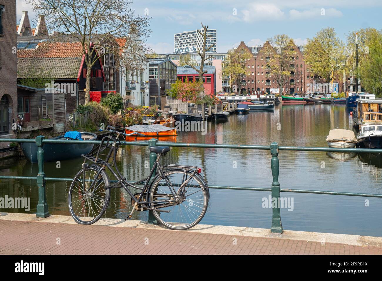 Bicycle parked on a bridge over a canal in Amsterdam. Stock Photo