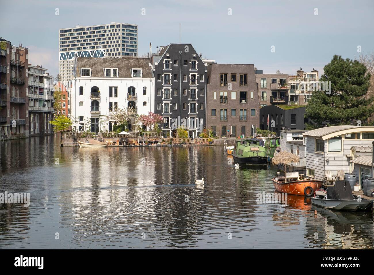 Houseboats, old and new apartments on a canal in Amsterdam. Stock Photo