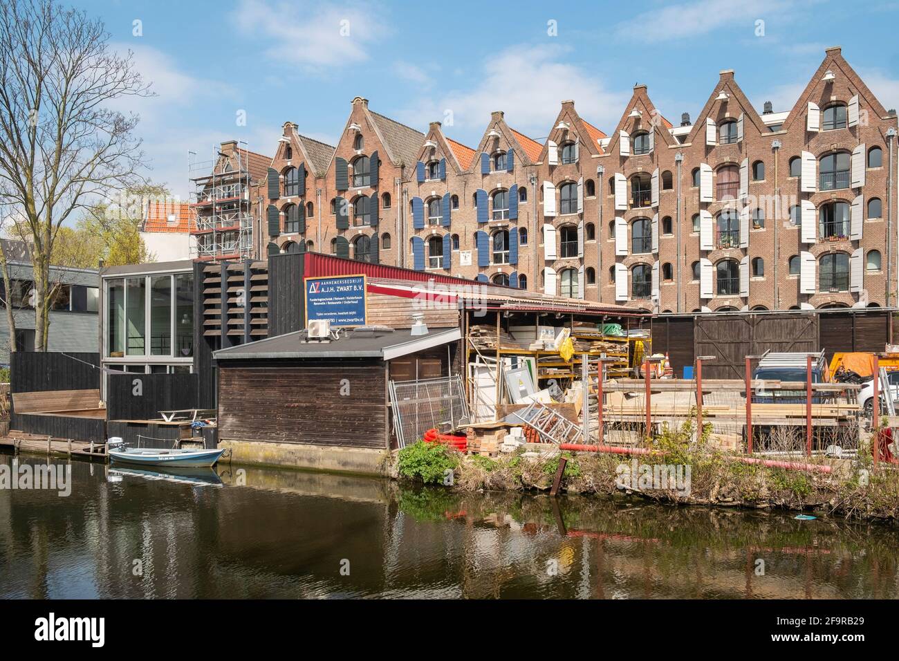 Canal side builders yard in front of renovated warehouses in Amsterdam. Stock Photo