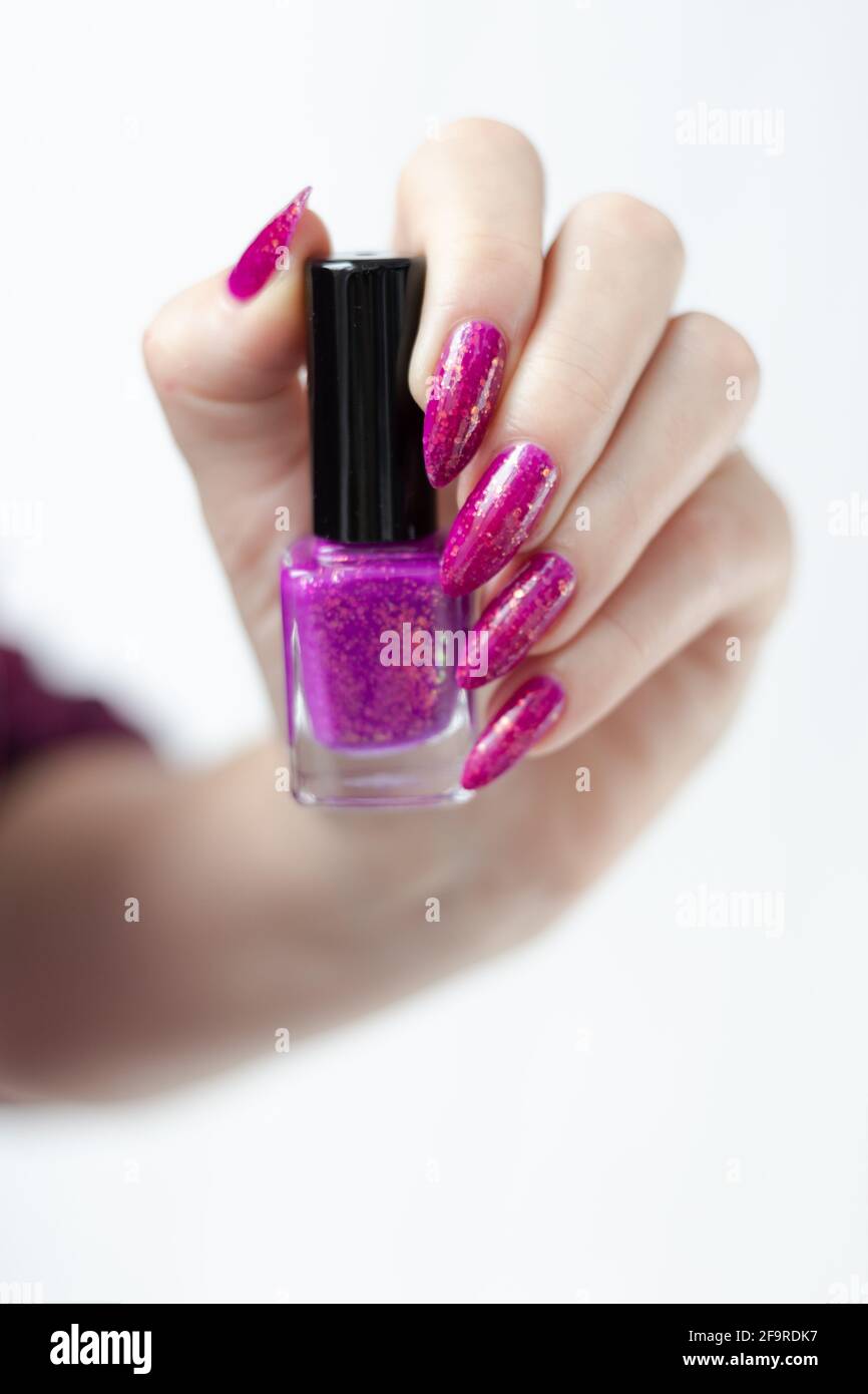 Woman's hands with long nails and pink fuchsia bottle manicure with nail  polish Stock Photo - Alamy