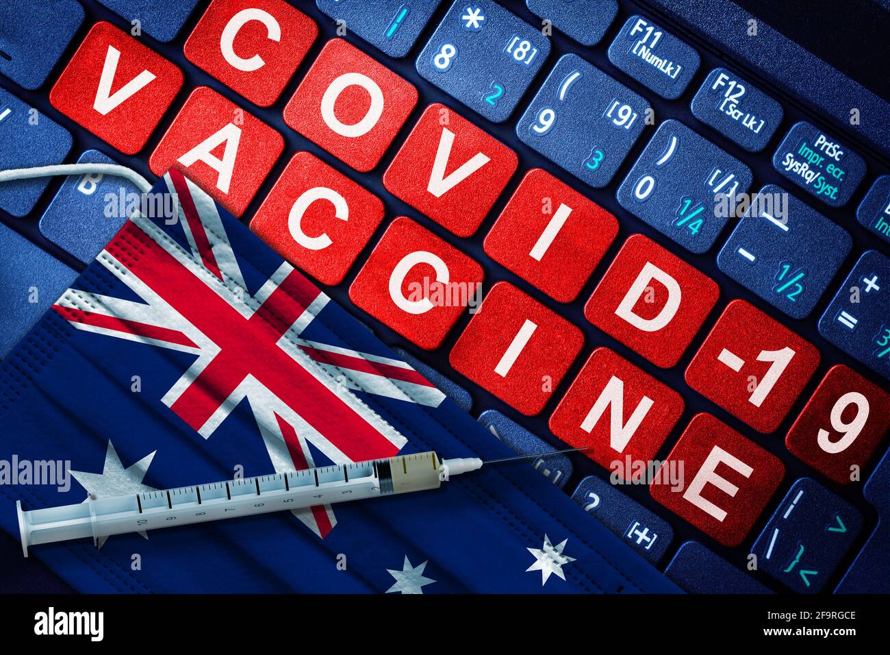 COVID-19 immunization in Australia showing syringe and face mask with Australian flag and vaccine message on computer keyboard. Concept of Covid vacci Stock Photo