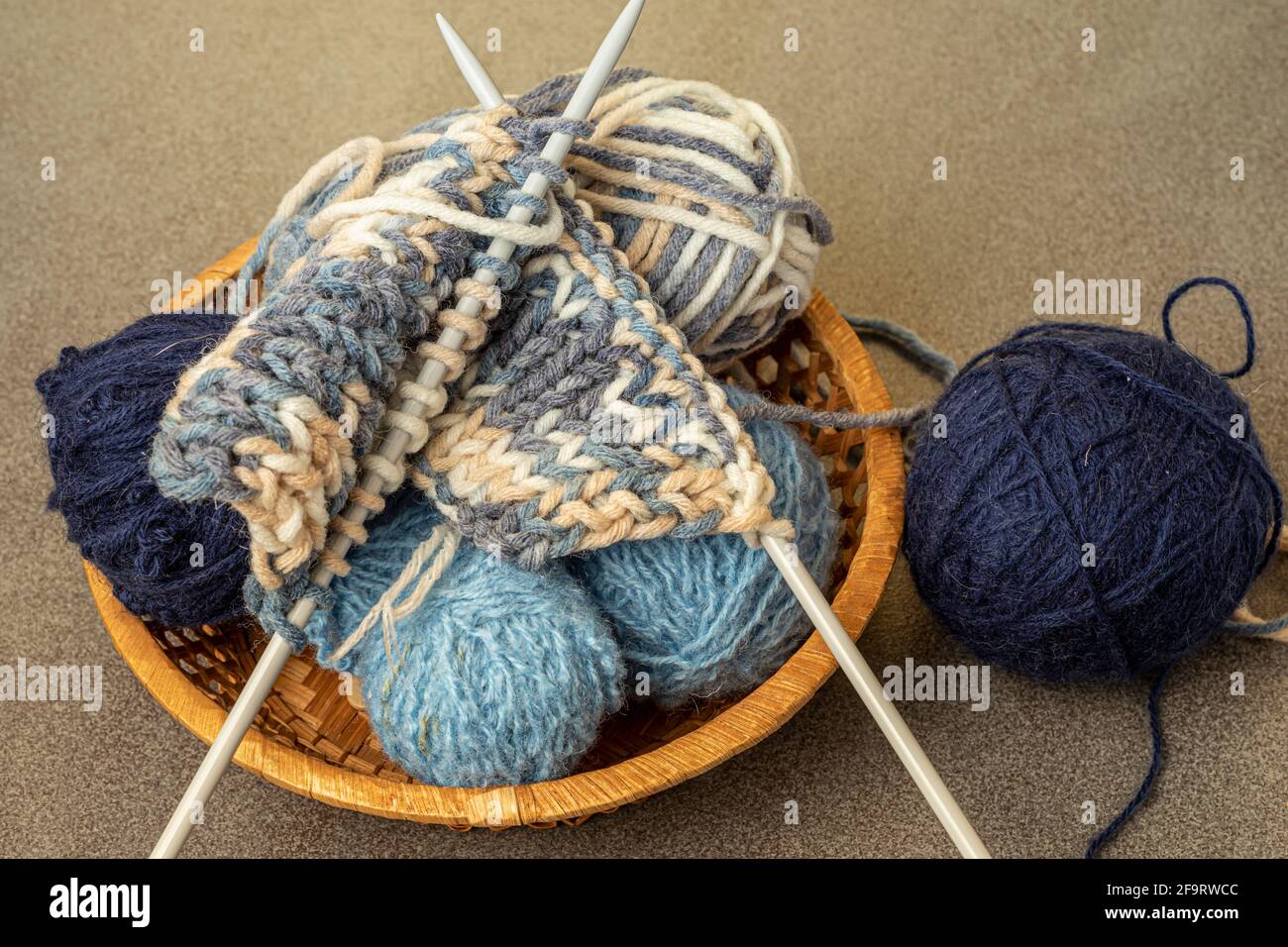 Knitting supplies close-up. Balls of knitting wool in a round wicker basket  Stock Photo - Alamy