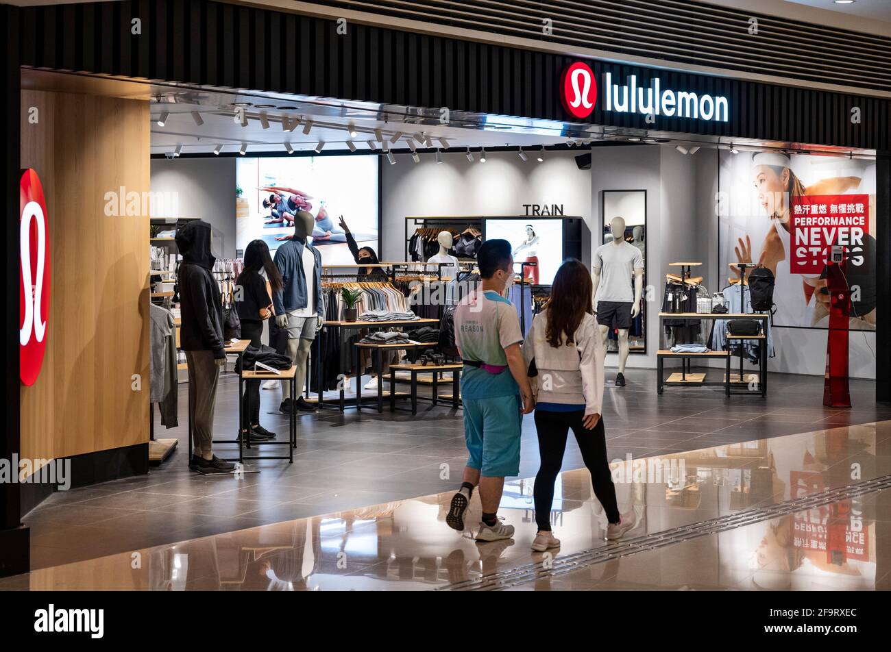 Hong Kong, China. 20th Apr, 2021. A couple walks past the Canadian  sportswear clothing band, Lululemon logo and store in Hong Kong. (Photo by  Budrul Chukrut/SOPA Images/Sipa USA) Credit: Sipa USA/Alamy Live