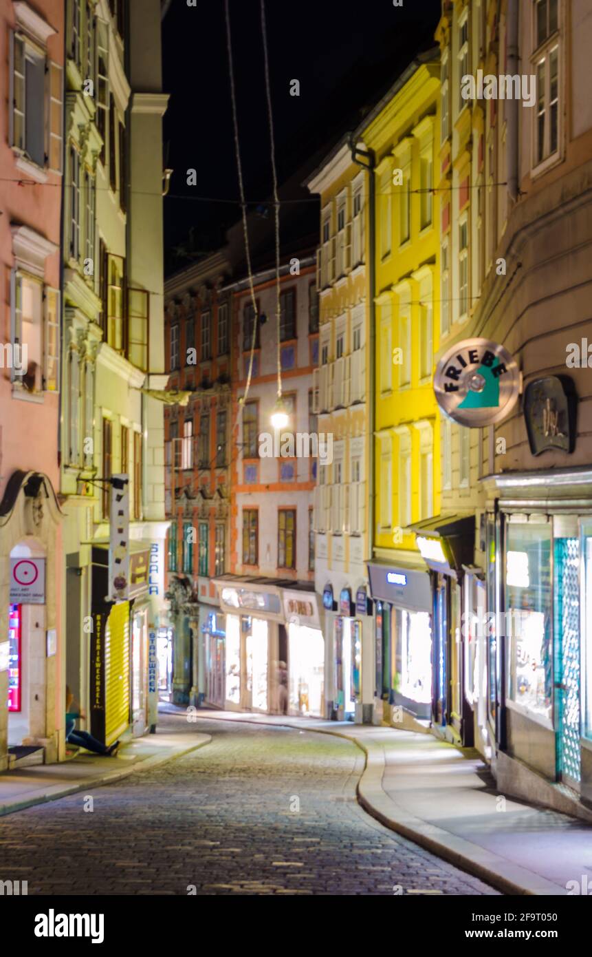 night view of an illuminated street in the historical center of Graz in ...