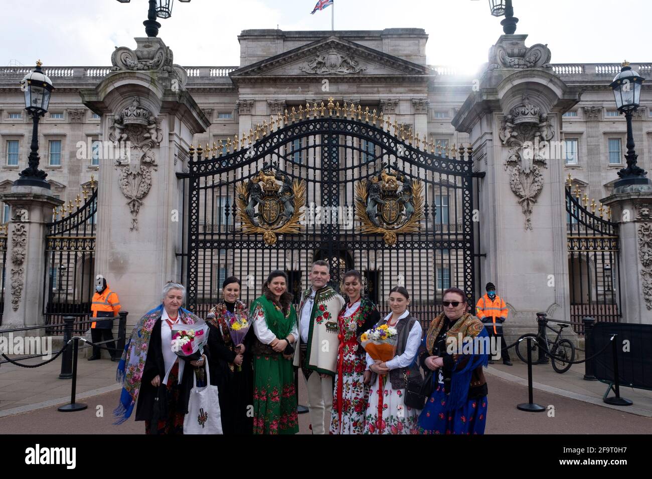 Polish family wearing traditional highlander dress arrive to lay floral tributes following the death of Prince Philip, Duke of Edingburgh outside Buckingham Palace on 11th April 2021 in London, United Kingdom. Members of the public have been laying flowers outside the gates of the royal residence following his passing at the age of 99 on 9th April 2021. Prince Philip, Duke of Edinburgh was a member of the British royal family as the husband of Elizabeth II. Philip was born into the Greek and Danish royal families. Stock Photo