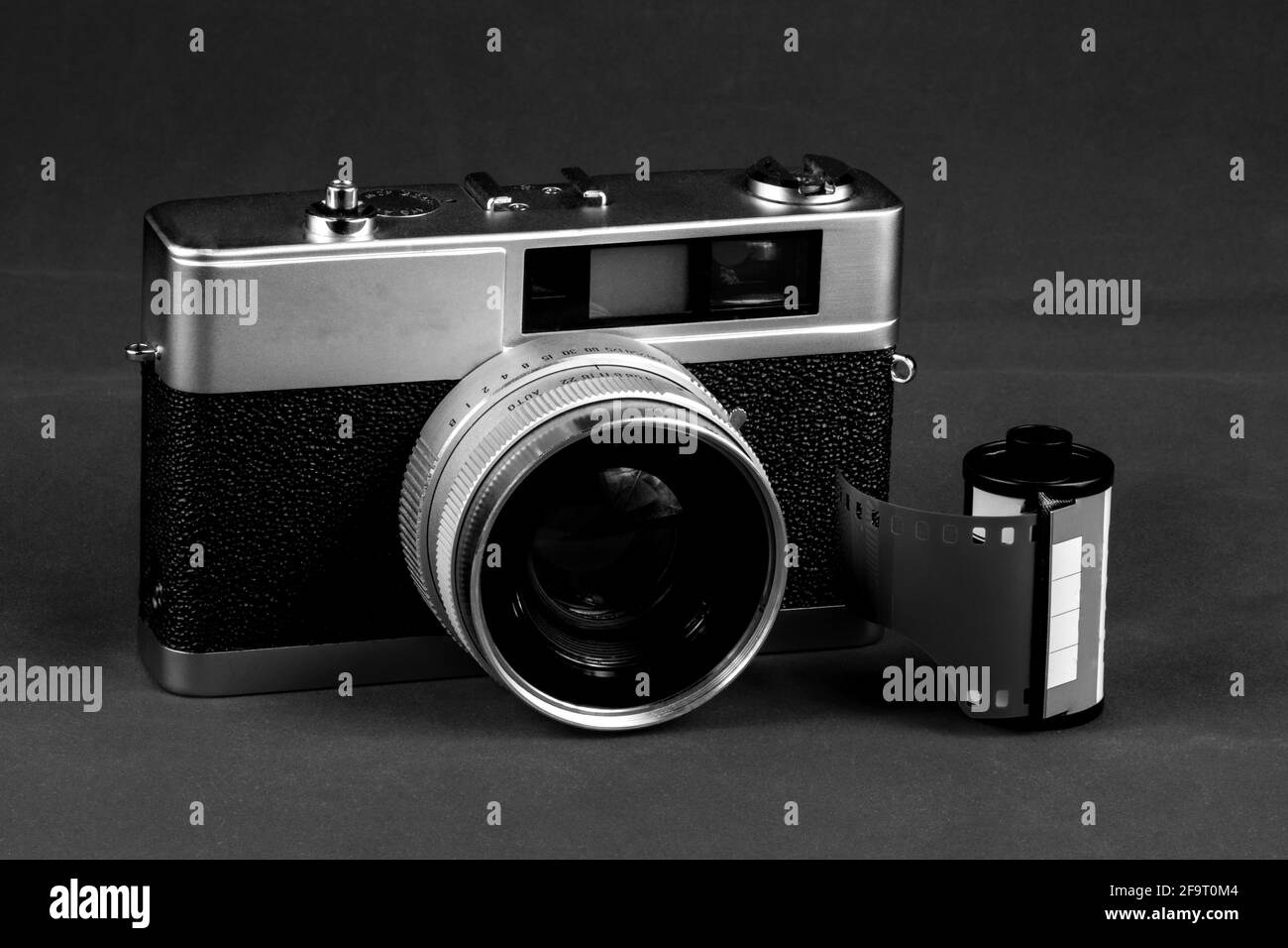 Monochrome vintage film rangefinder camera with roll of film Stock Photo