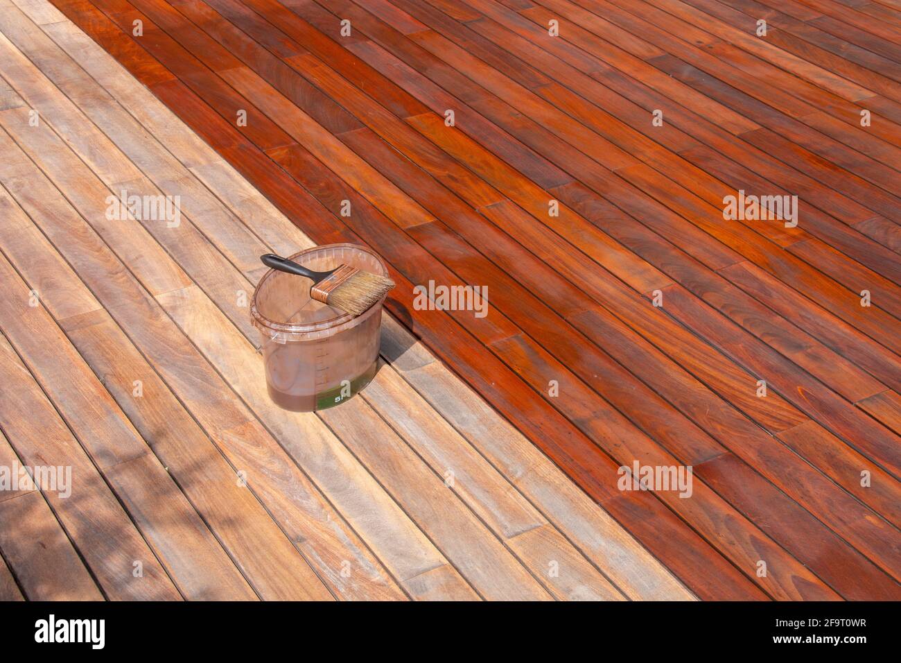 Wood deck renovation treatment and maintenance concept, paint brush on