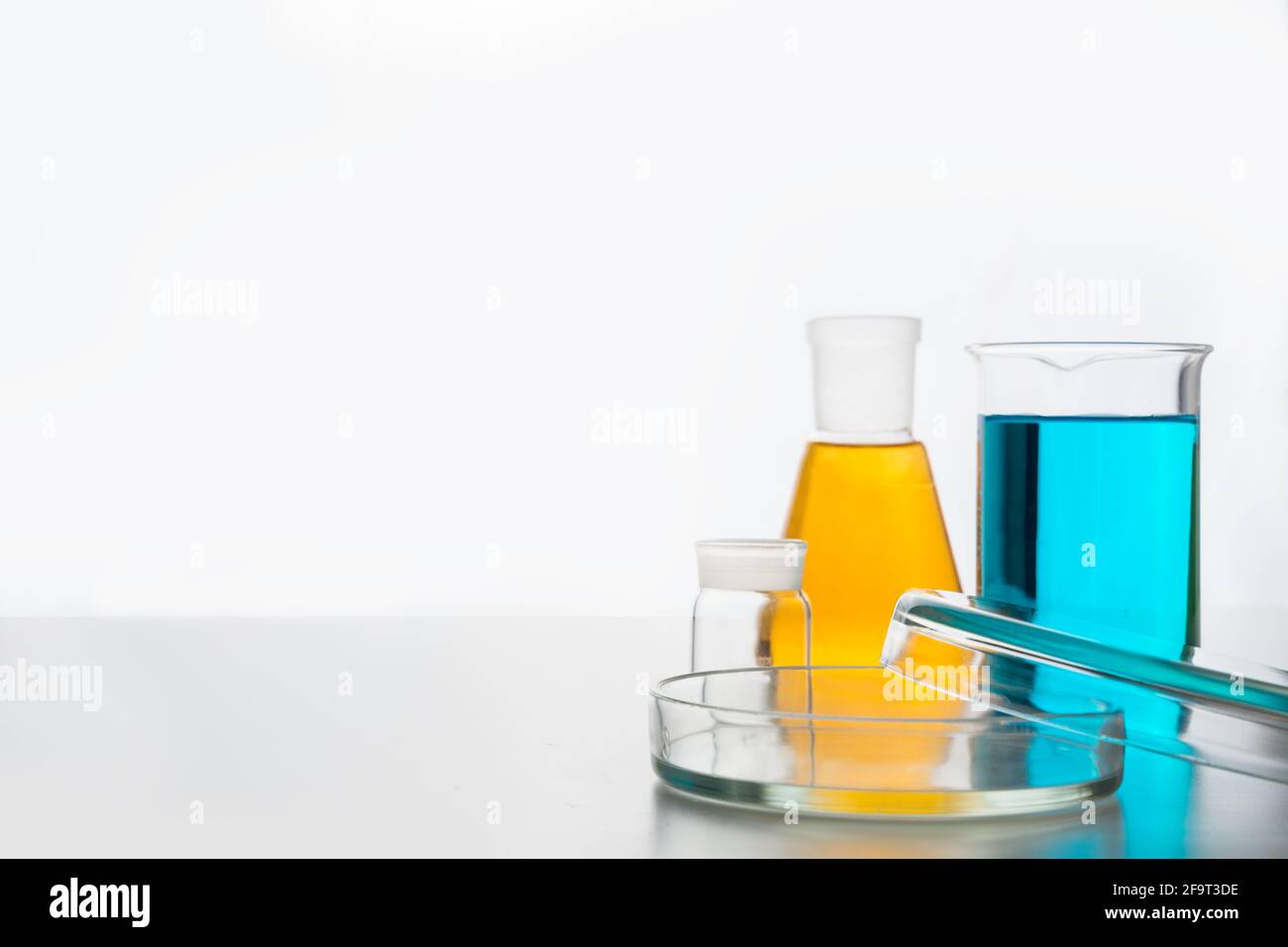 Chemistry glassware with yellow and blue liquid for science research ...