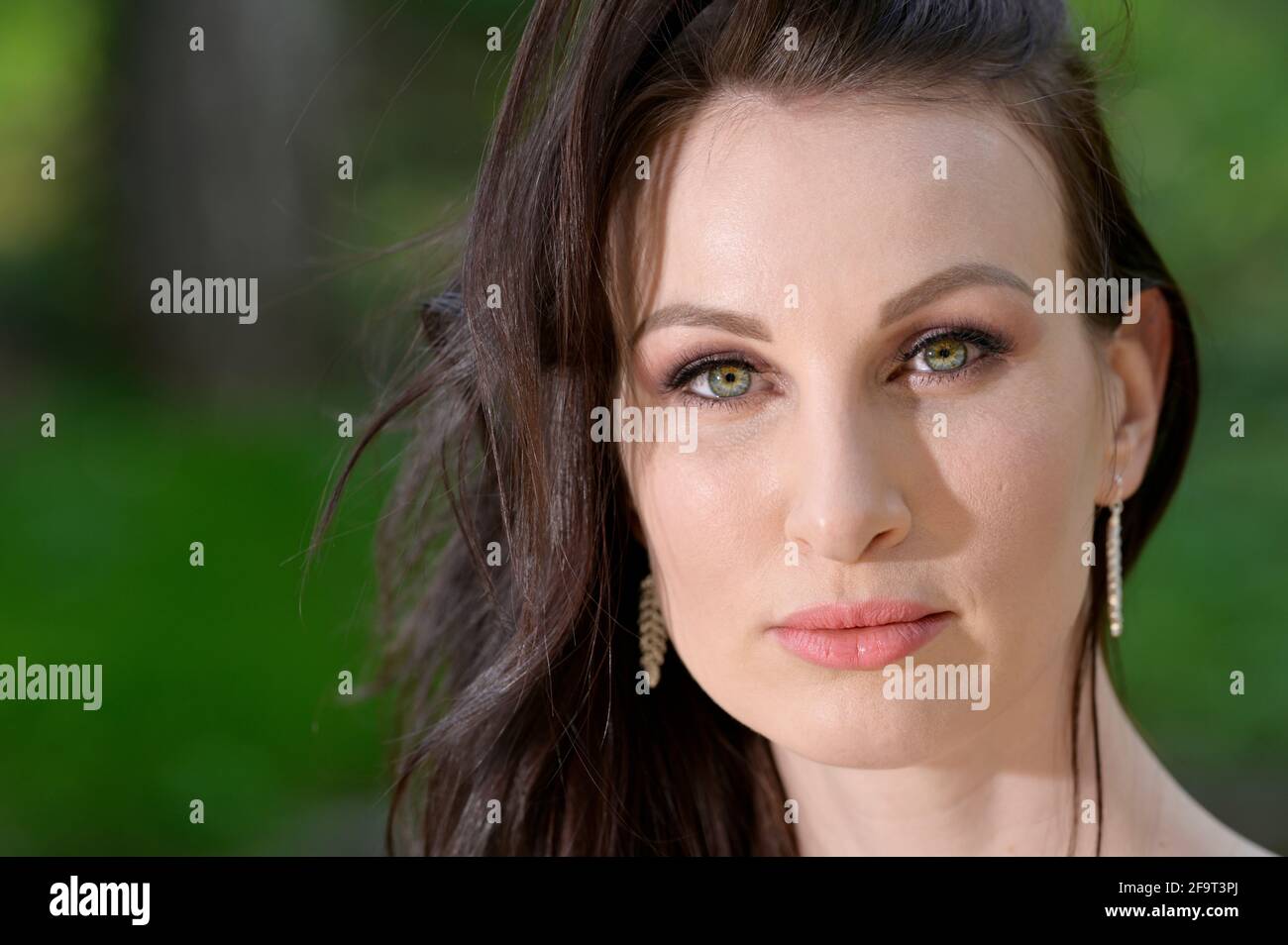 A beautiful young Russian woman in a park in the first warm spring sun. Stock Photo