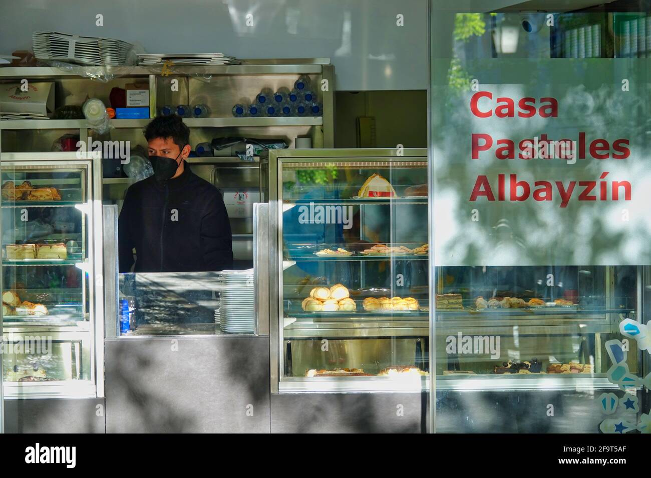 Open entrance with the waiter behind the counter of a famous pastry-cafeteria in the Albaicín de Granada (Spain) Stock Photo